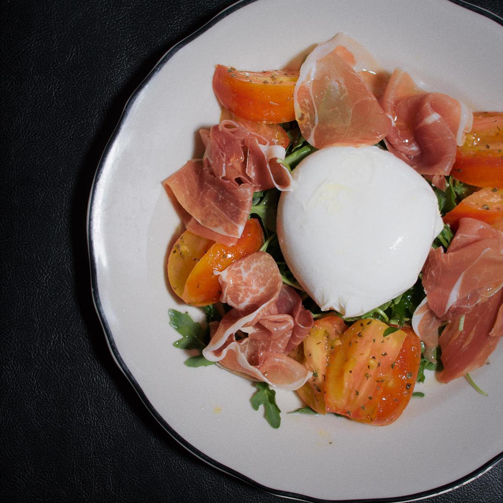 Burrata, prosciutto, tomatoes, and arugula served at Civico 1845