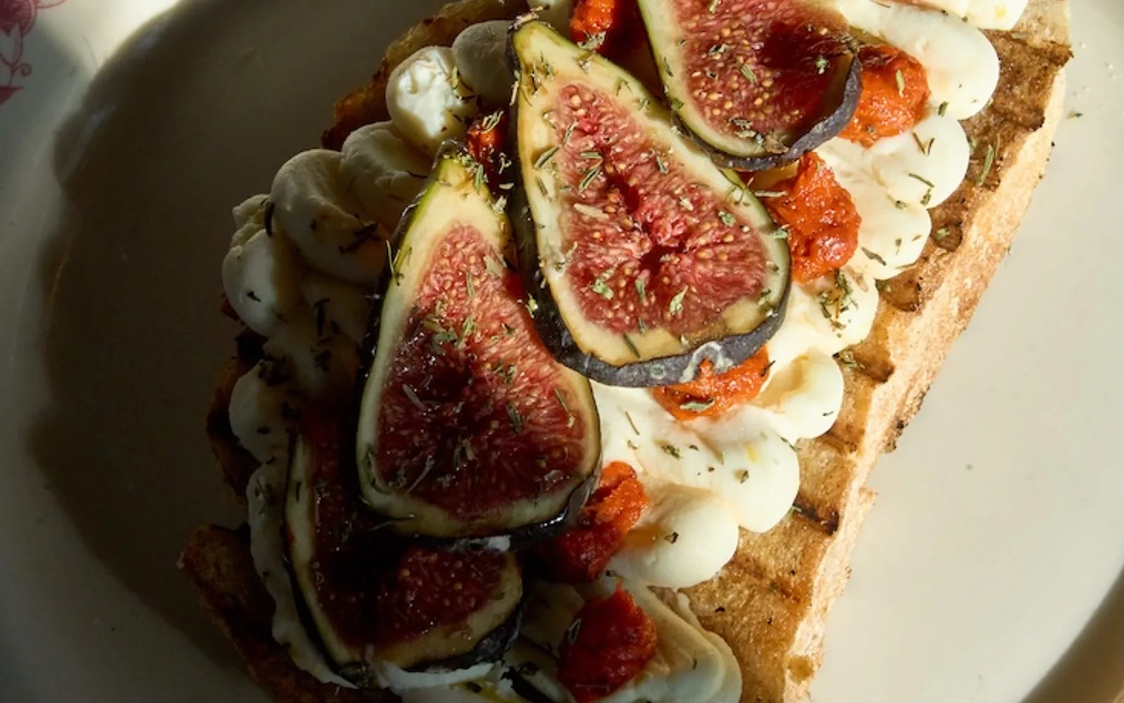 Fig crostini with a creamy topping and red sauce on Civico 1845 tableware